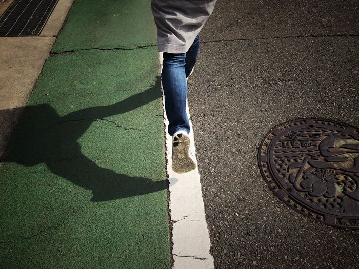 Low section of woman running on footpath
