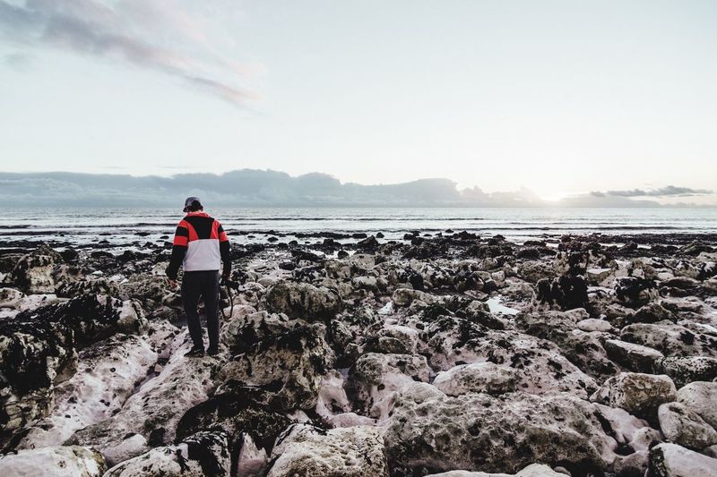 Man standing on rocks at beach