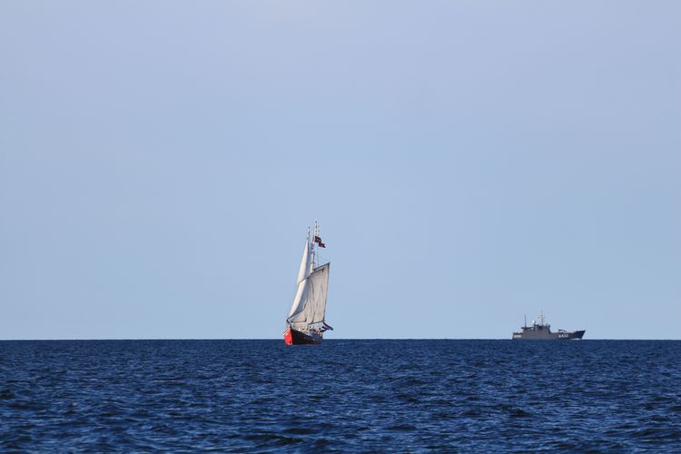 Boat sailing in sea against clear sky