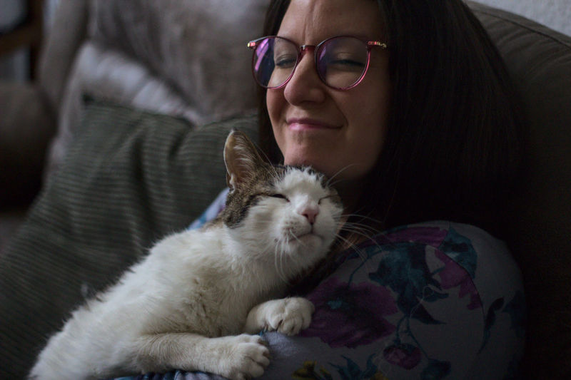 Happy woman with glasses together with her loving cat