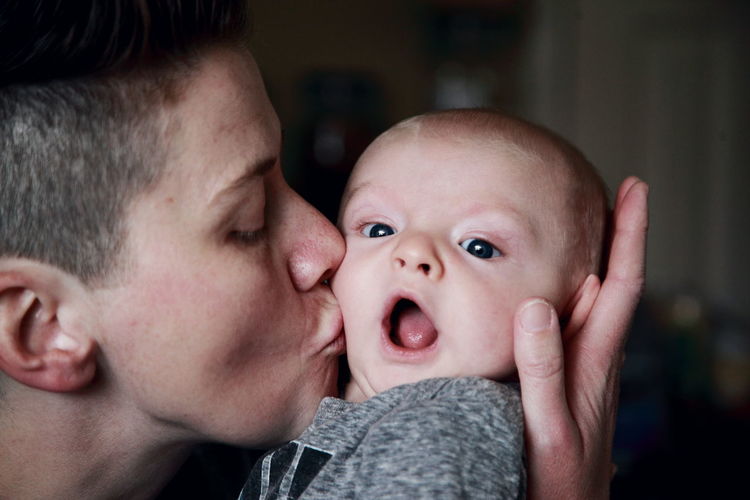 Mother kissing baby son at home