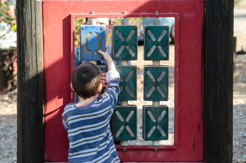 Siblings playing wooden tic-tac-toe in playground