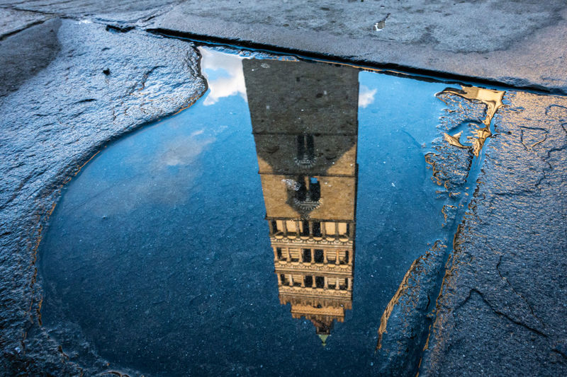 Reflection of old building in puddle