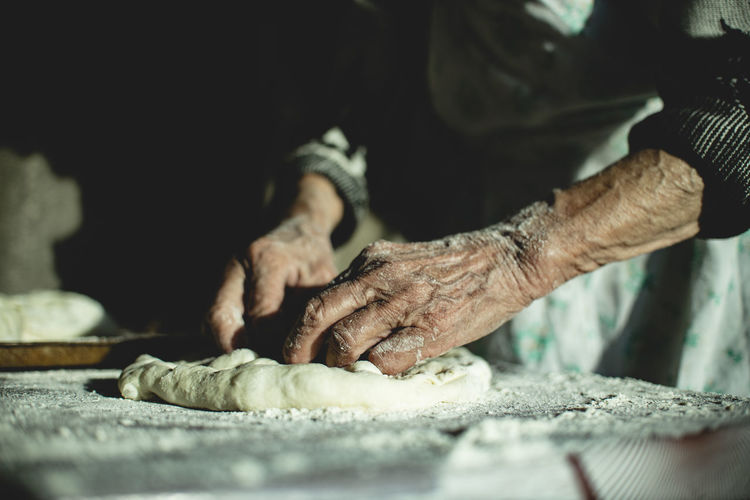 Georgian old woman is bakind bread.