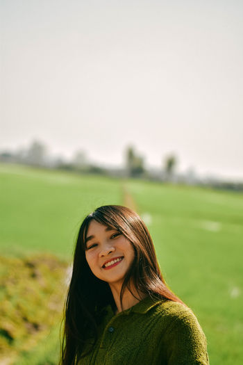 Portrait of a smiling young woman on field