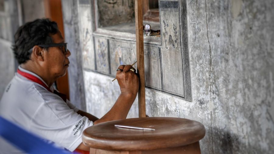 Mature woman painting on wall