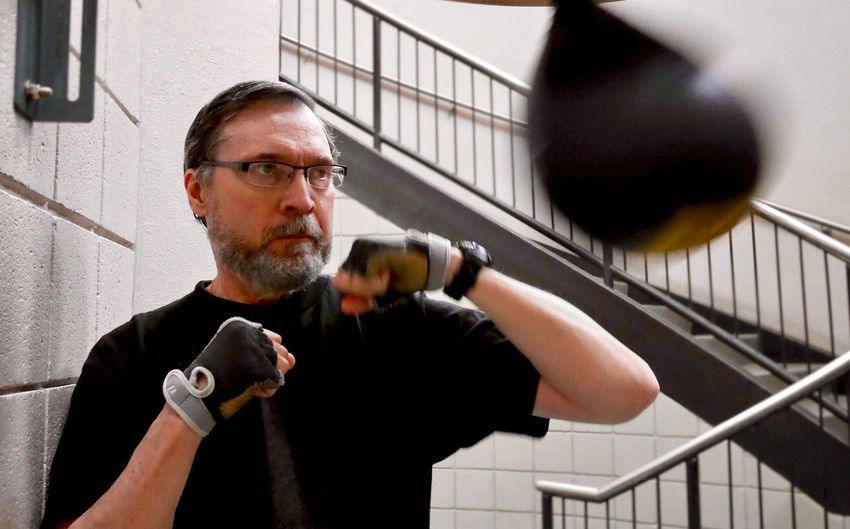 Senior man practicing boxing at gym