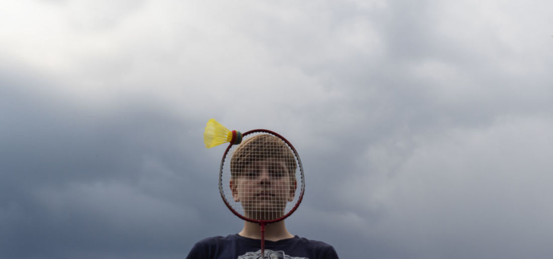 Close-up of boy with badminton and shuttlecock