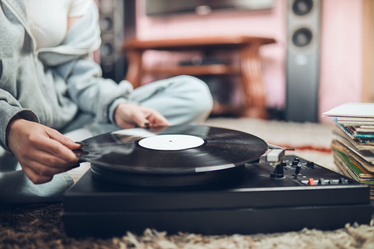 Young woman listening to music from vinyl record player. retro and vintage style. hobby and passion