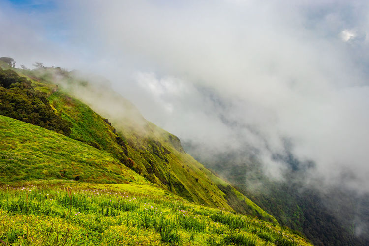 Mountain with green grass and thick clouds