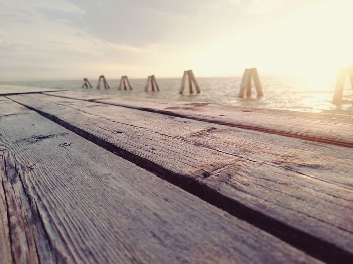 Wooden pier at lake neusiedl during sunset