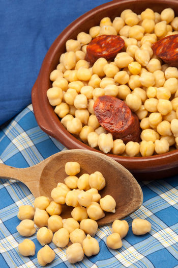 High angle view of chickpeas and sausages in bowl on table