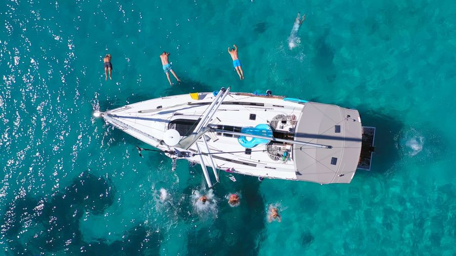Top view of young friends jumping from sailboat. yachting. summer luxury boat trip