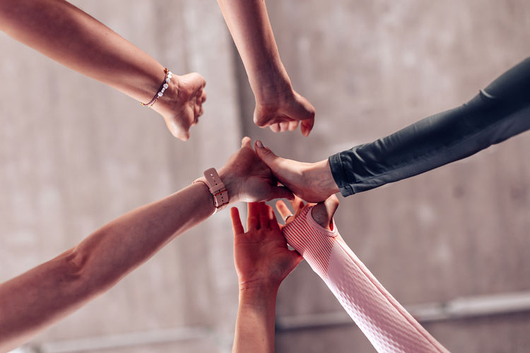 Bottom view of female hands team high fiving each other. group of people giving high five.