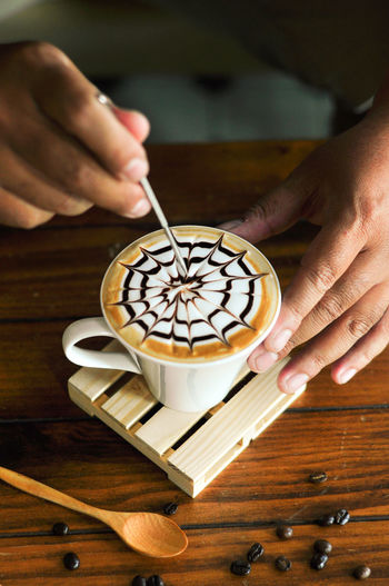 Hand holding coffee cup on table