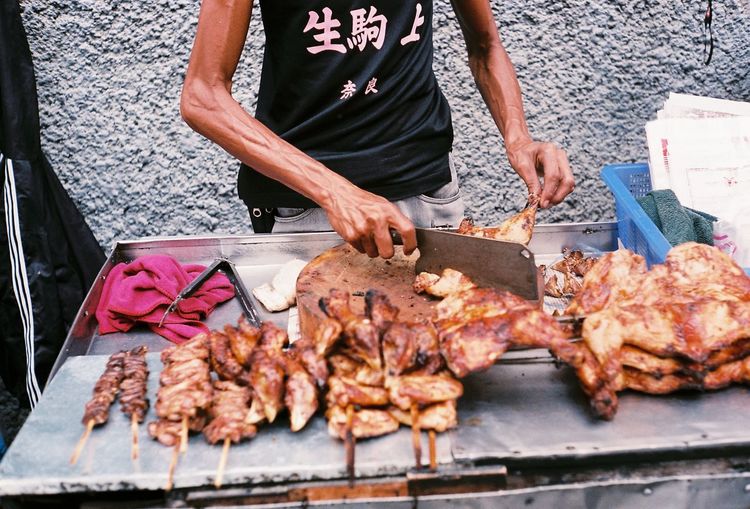 Man holding meat on barbecue grill