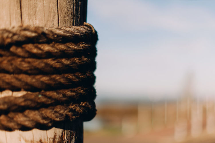Close-up of rope tied to wooden post