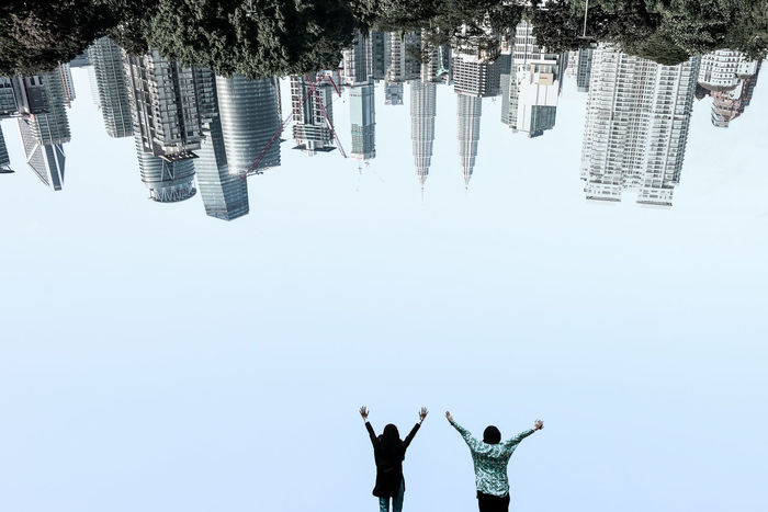 View of two people in city against clear sky