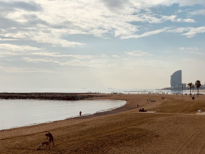 Scenic view of beach against cloudy sky at la barcelonetta beach in barcelona 