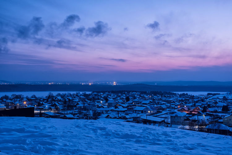 Scenic view of townscape against sky during winter