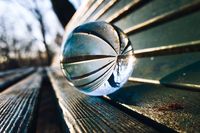 High angle view of crystal ball on wooden bench