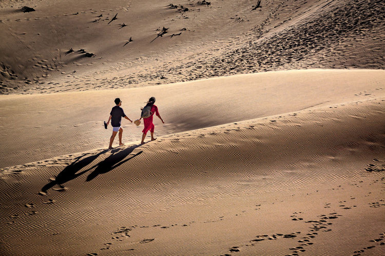 People walking on sand at beach