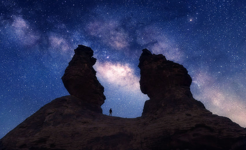LOW ANGLE VIEW OF HUMAN FEET AGAINST SKY