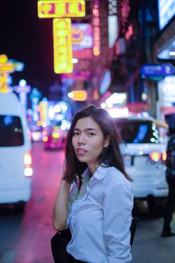 Portrait of woman standing on city street at night