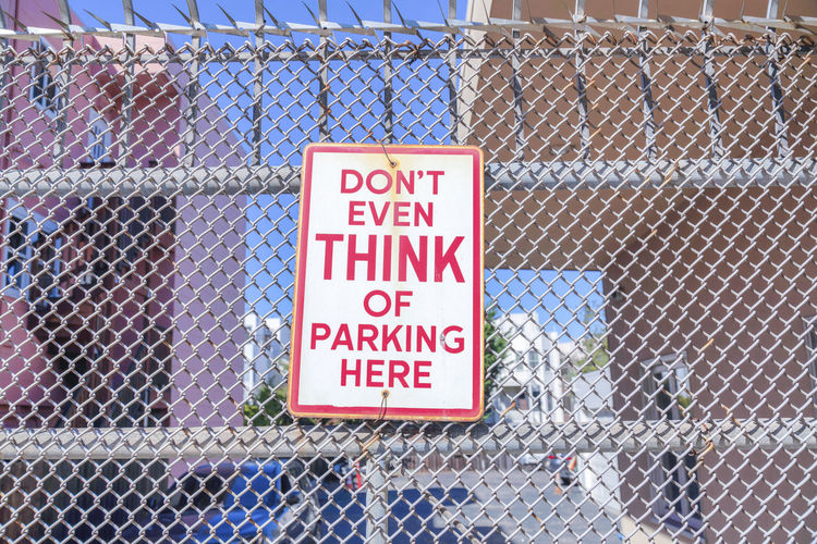 Close-up of sign on chainlink fence