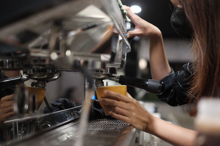 Cropped hand of woman barista making good coffee
