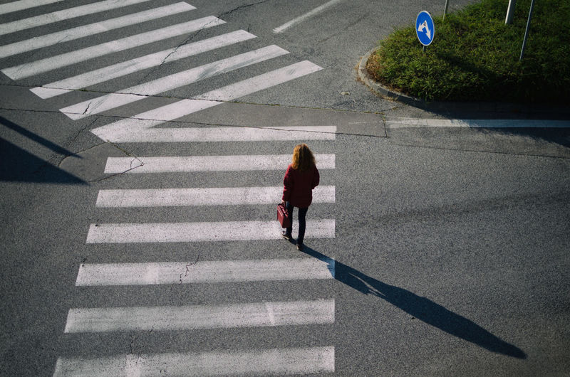 Rear view of woman walking on road