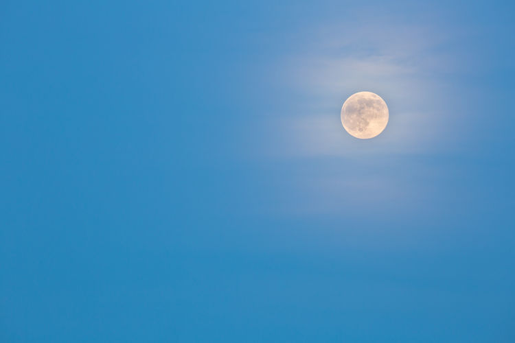 Low angle view of moon against blue sky