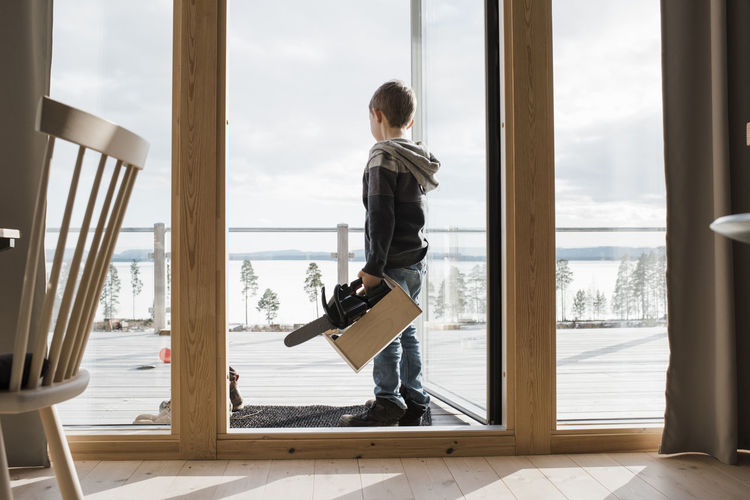 Boy playing with toy tools at his home overlooking the sea