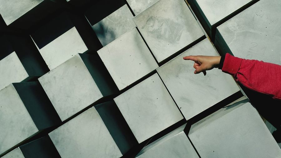 Close-up of hand pointing towards blocks