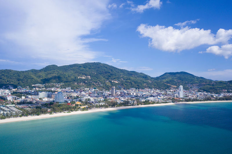 Scenic view of sea by buildings against sky