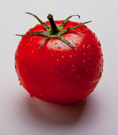 Close-up of wet strawberry against white background