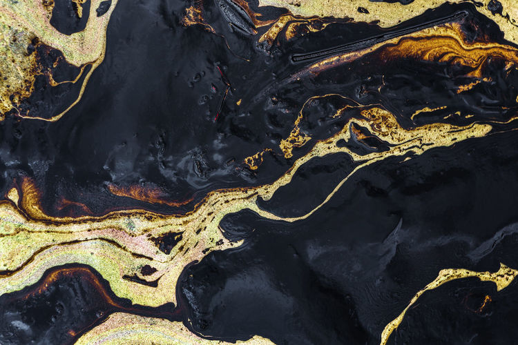 Texture of crude oil spill on sand beach from oil spill accident