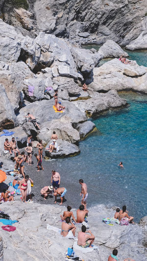 High angle view of people enjoying at rocky beach