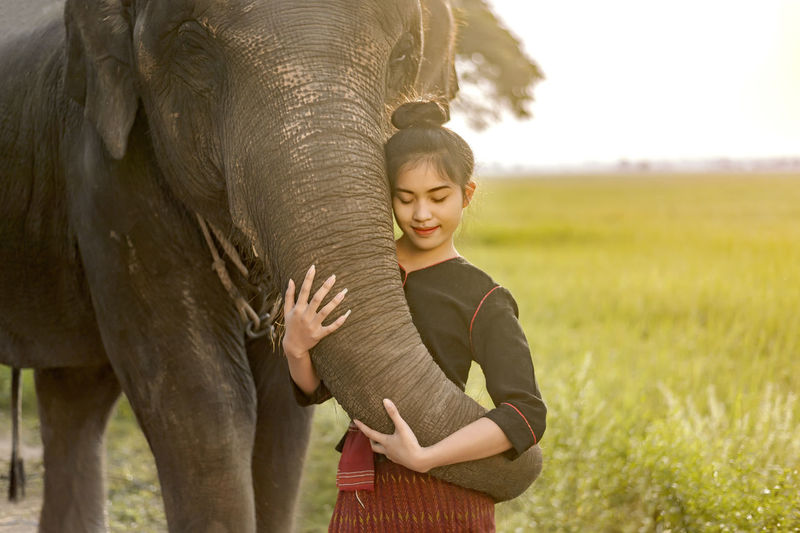 Full length of woman standing against elephant