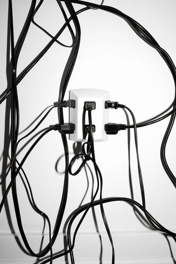 Close up of electrical plugs plugged into an outlet with messy wires