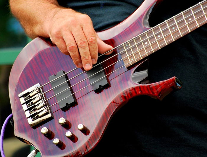 Close-up of man playing bass guitar