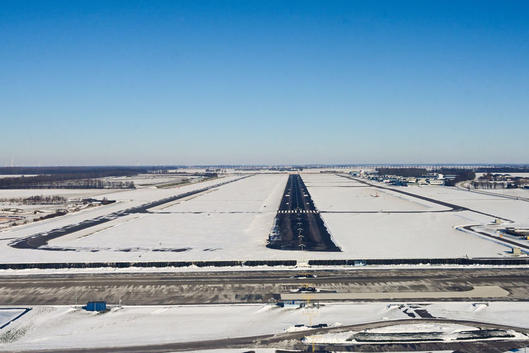 View of airport runway against clear blue sky