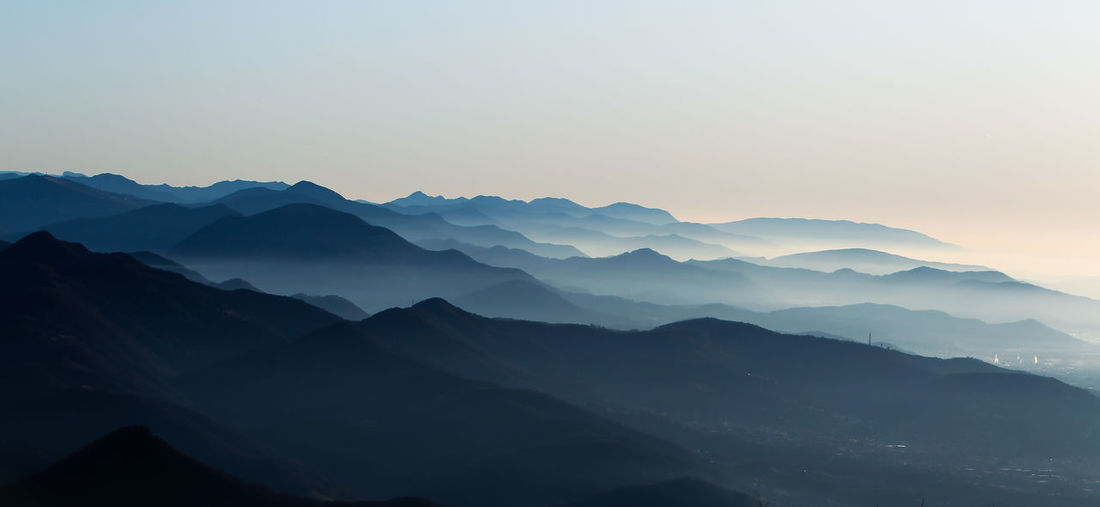 Scenic view of mountains against clear sky during sunset