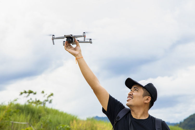 Smiling man holding drone outdoors
