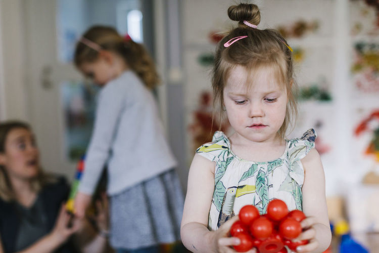 Girl in playschool holding toys