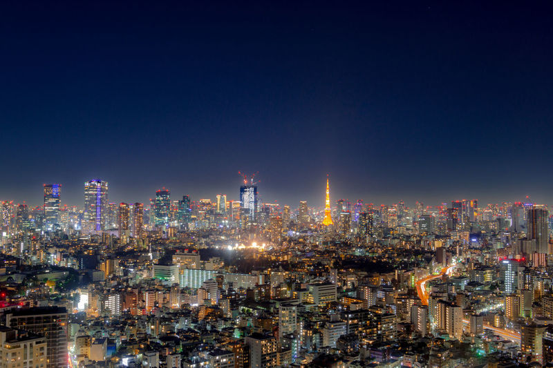 Illuminated cityscape against sky at night