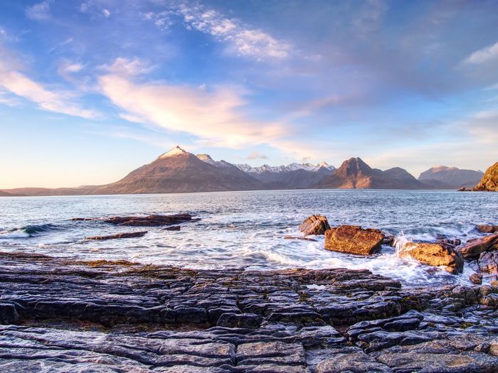 Peaceful dawn at elgol bay. sharp offshore rocks and smooth sea. winter isle of skye, scotland