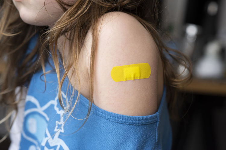 Little girl with a band-aid on her hands, vaccinated against coronavirus infection. vaccination