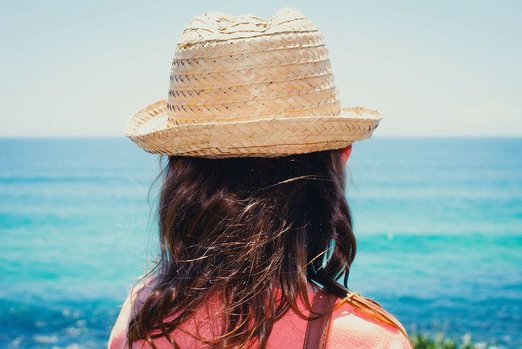 Rear view of woman wearing sunhat against sea