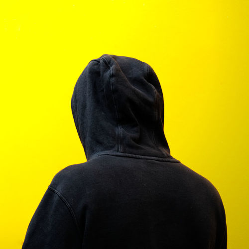 Rear view of man against yellow background